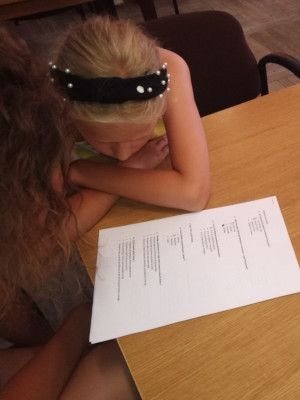 Zdjęcie z zajęć "Zgaduj zgadula jaka to lektura" - dziewczynki rozwiązujące zadania