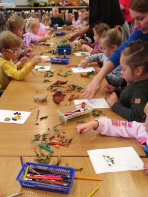 Zdjęcie z zajęć - dzieci wyklejają jeża z kolorowych liści