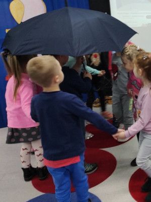 Zdjęcie z zajęć - dzieci tańczące pod parasolem